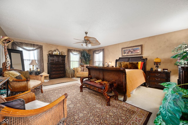 bedroom with carpet floors, a textured ceiling, and ceiling fan