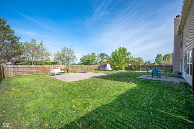 view of yard featuring a patio, a fenced backyard, and a storage shed