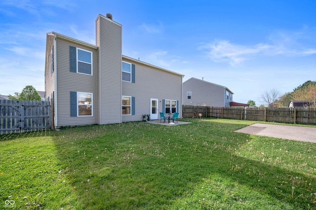 rear view of house featuring a fenced backyard, a patio area, a yard, and a chimney
