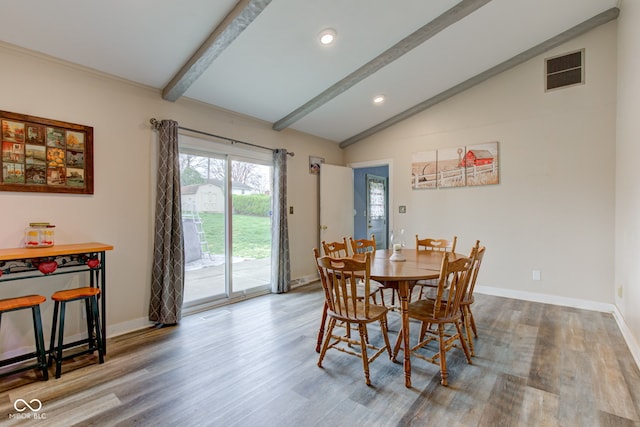 dining area with wood finished floors, baseboards, vaulted ceiling with beams, and visible vents