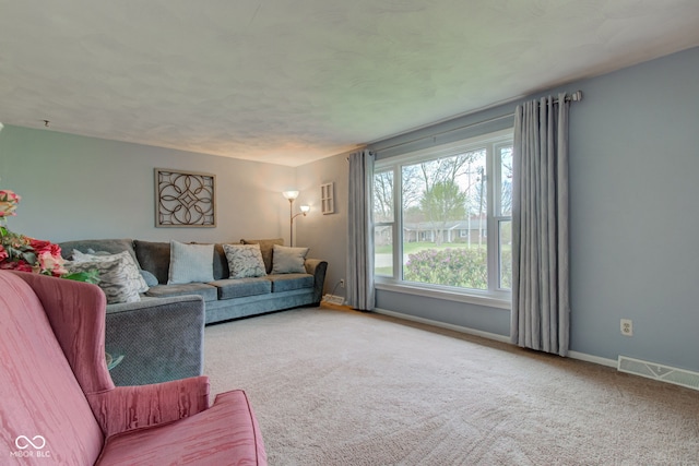 carpeted living area featuring baseboards and visible vents