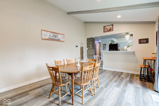 dining room featuring lofted ceiling with beams, baseboards, wood finished floors, and ceiling fan