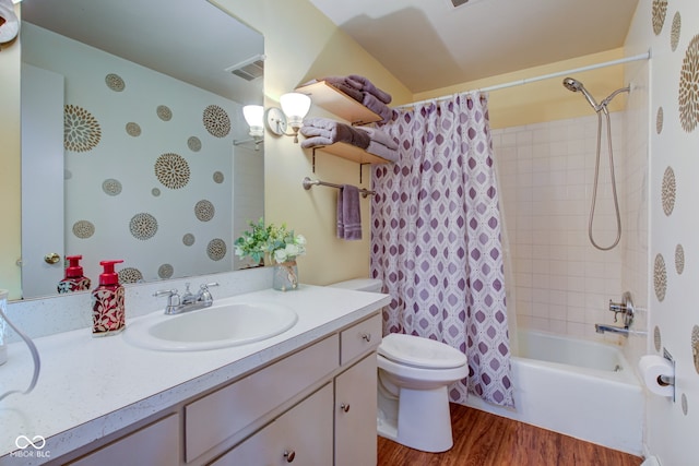 full bathroom with shower / bath combo, wood finished floors, vanity, toilet, and visible vents