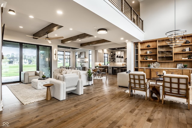 living room featuring beam ceiling, a ceiling fan, recessed lighting, and wood finished floors