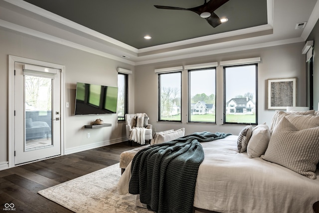 bedroom featuring wood-type flooring, visible vents, ornamental molding, and a raised ceiling