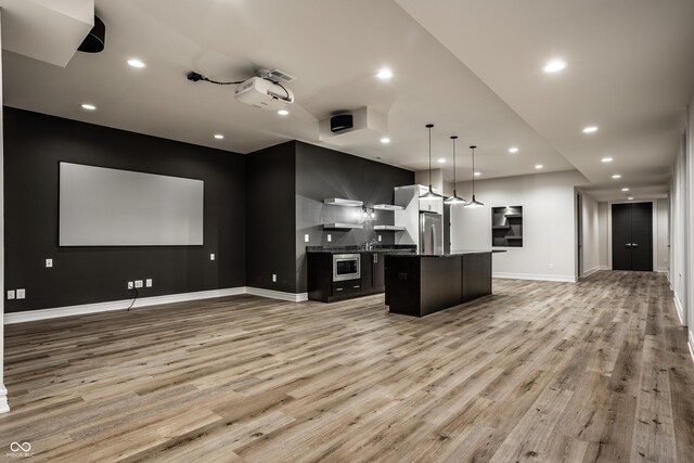 kitchen with freestanding refrigerator, open floor plan, light wood-style floors, and a center island