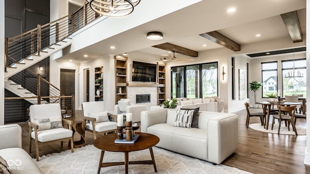 living room featuring a fireplace, stairs, wood finished floors, baseboards, and recessed lighting