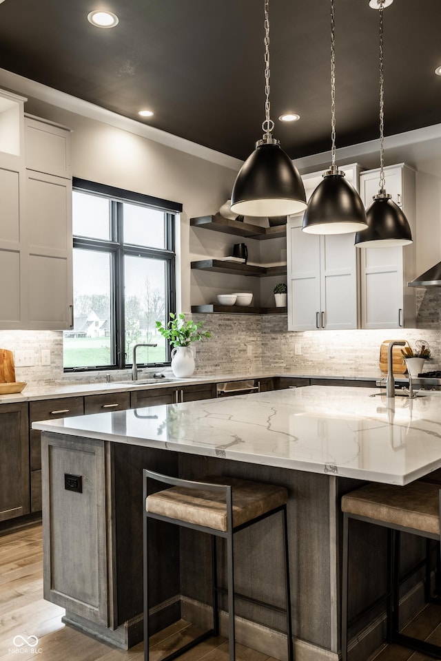 kitchen featuring crown molding, backsplash, open shelves, and a breakfast bar