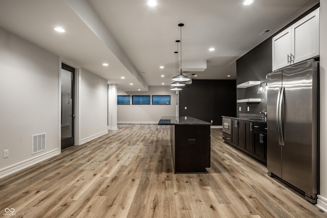 kitchen with freestanding refrigerator, recessed lighting, open floor plan, and visible vents
