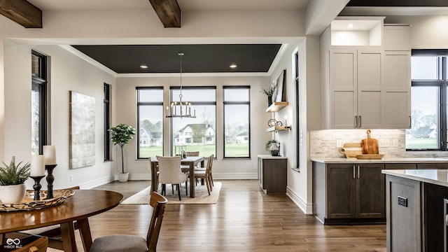 bar with backsplash, beamed ceiling, a wealth of natural light, and dark wood-type flooring