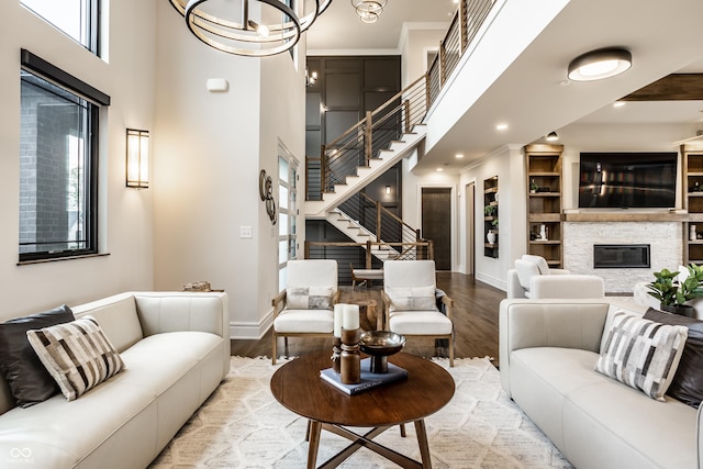 living area with baseboards, stairs, wood finished floors, and a fireplace