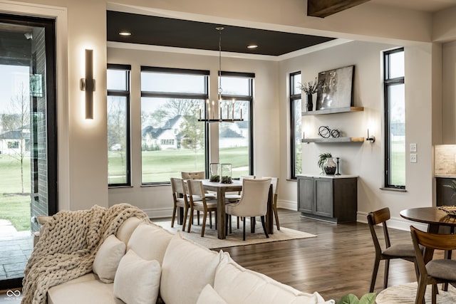 dining space with a notable chandelier, baseboards, and dark wood finished floors