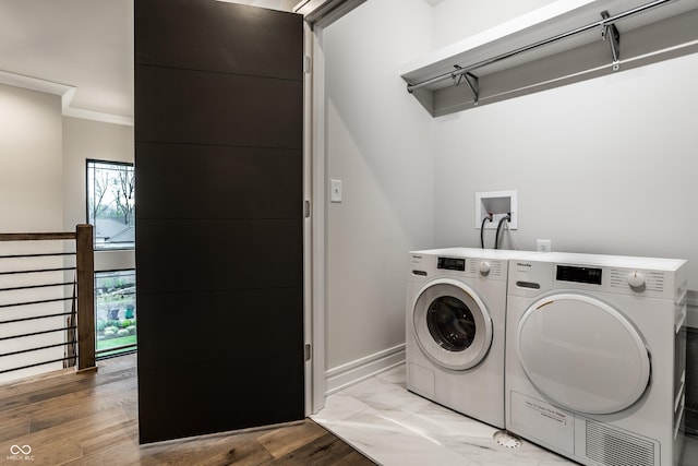 washroom featuring crown molding, separate washer and dryer, laundry area, and baseboards