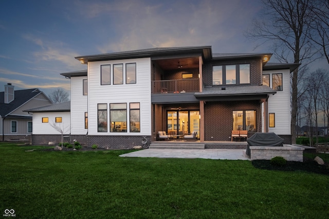 back of property with brick siding, an outdoor living space, a patio area, a balcony, and a yard