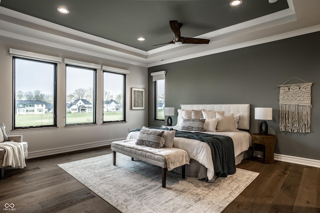 bedroom with crown molding, recessed lighting, dark wood finished floors, and a raised ceiling