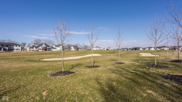 view of property's community featuring a residential view and a yard