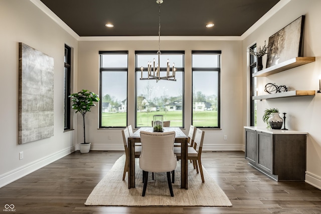 dining space featuring crown molding, dark wood finished floors, a wealth of natural light, and an inviting chandelier