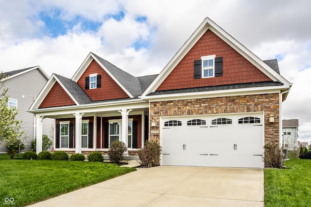 craftsman house featuring a front lawn, stone siding, concrete driveway, and a garage