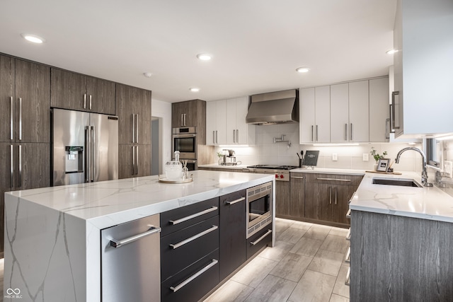 1995 W 116th St, Carmel, IN 46032 - kitchen featuring a kitchen island, modern cabinets, wall chimney range hood, a sink, and stainless steel appliances