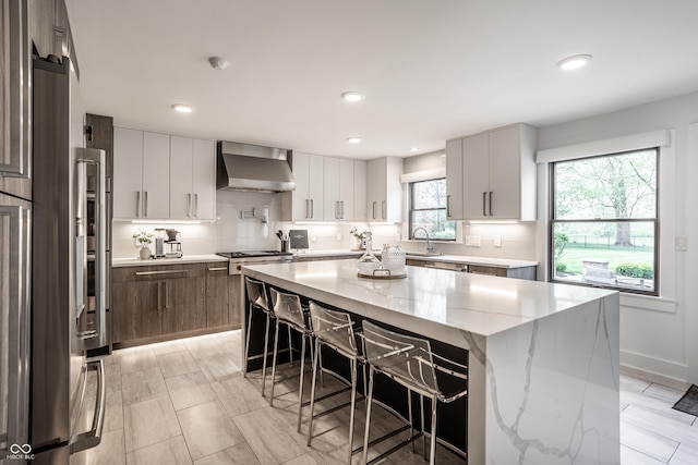 1995 W 116th St, Carmel, IN 46032 - kitchen with recessed lighting, wall chimney exhaust hood, and a breakfast bar