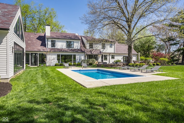 1995 W 116th St, Carmel, IN 46032 - rear view of house with a lawn, a patio area, an outdoor pool, and a chimney