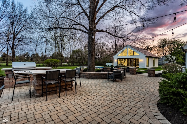 1995 W 116th St, Carmel, IN 46032 - patio terrace at dusk featuring outdoor dry bar, a grill, and area for grilling