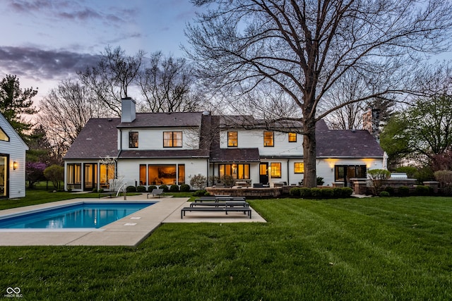 1995 W 116th St, Carmel, IN 46032 - back of property featuring a chimney, a yard, a patio area, and an outdoor pool