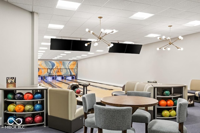 game room featuring a bowling alley, a chandelier, and a paneled ceiling