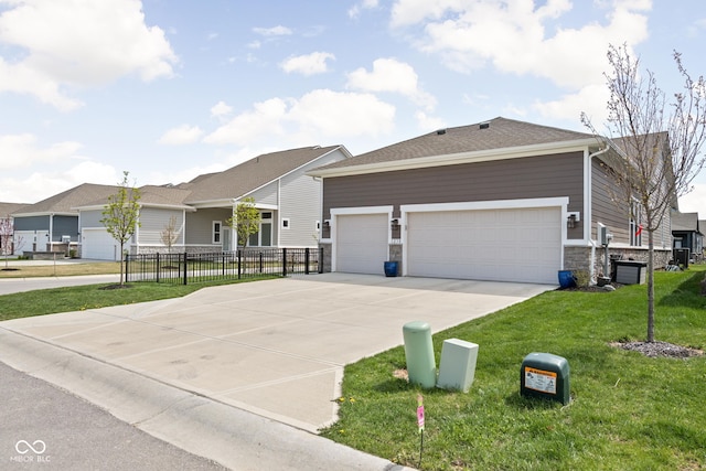 single story home featuring driveway, a front yard, fence, an attached garage, and stone siding