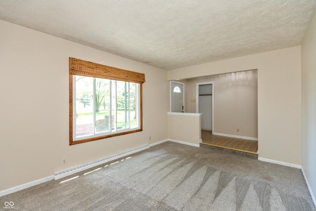 spare room featuring a textured ceiling, baseboards, carpet, and a baseboard radiator