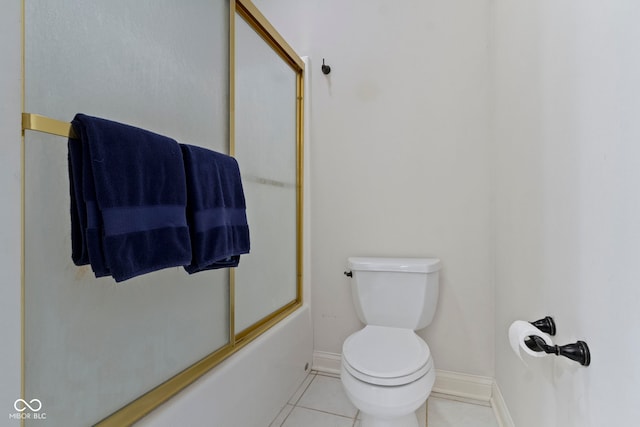 full bath featuring baseboards, shower / bath combination with glass door, tile patterned floors, and toilet