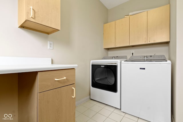 clothes washing area featuring cabinet space, separate washer and dryer, baseboards, and light tile patterned floors
