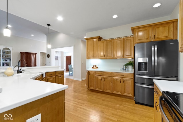 kitchen featuring a sink, light countertops, and refrigerator with ice dispenser