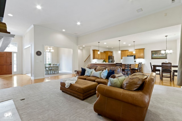 living room featuring stairs, recessed lighting, an inviting chandelier, and ornamental molding