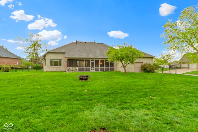 back of house featuring a fire pit, fence, stone siding, a sunroom, and a yard