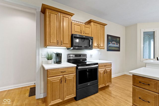 kitchen with light countertops, baseboards, light wood finished floors, and electric range