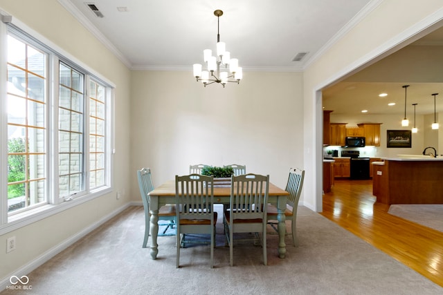 dining space with visible vents, crown molding, and a notable chandelier