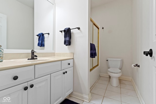 full bathroom featuring tile patterned flooring, vanity, toilet, baseboards, and combined bath / shower with glass door