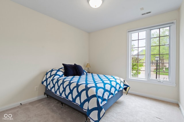 carpeted bedroom featuring baseboards and visible vents