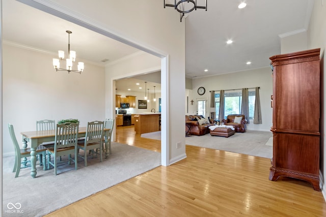 dining area featuring an inviting chandelier, ornamental molding, light wood finished floors, and recessed lighting