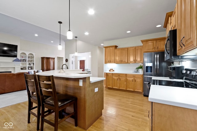 kitchen featuring light wood-type flooring, open floor plan, black appliances, and light countertops