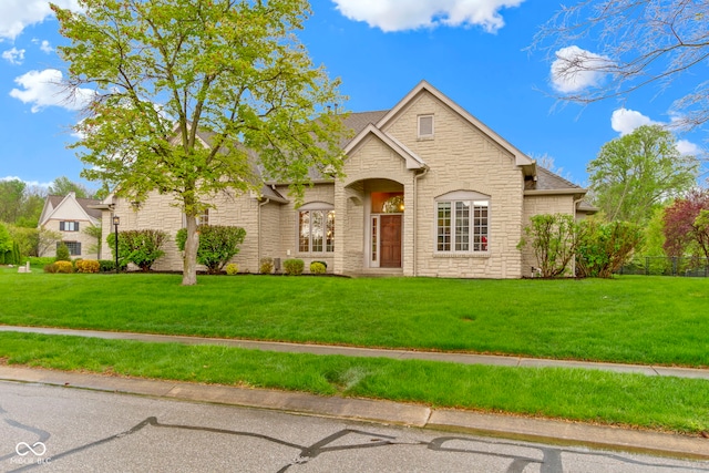 view of front of house with a front yard and stone siding