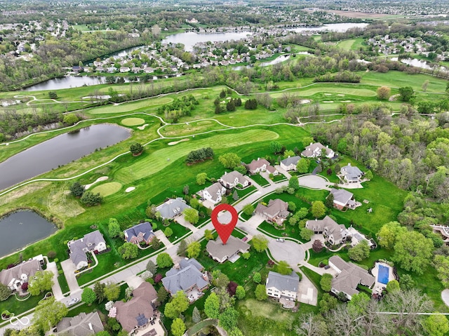 drone / aerial view with a water view, view of golf course, and a residential view