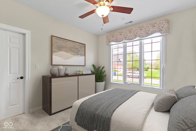 bedroom with light colored carpet, a ceiling fan, baseboards, and visible vents
