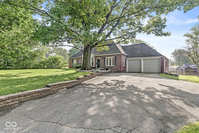 5747 Allisonville Rd, Indianapolis, IN 46220 - view of front of house featuring a front lawn, a garage, aphalt driveway, brick siding, and fence