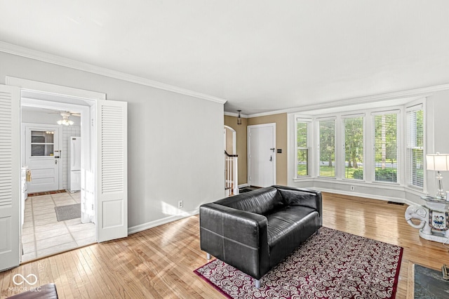 5747 Allisonville Rd, Indianapolis, IN 46220 - living room featuring crown molding, visible vents, light wood-style floors, baseboards, and arched walkways