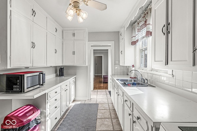 5747 Allisonville Rd, Indianapolis, IN 46220 - kitchen featuring stainless steel microwave, a sink, white cabinets, and light countertops