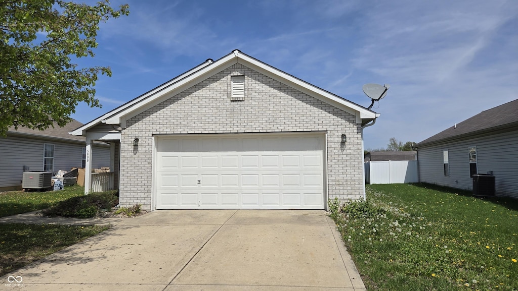 garage with central AC unit and fence