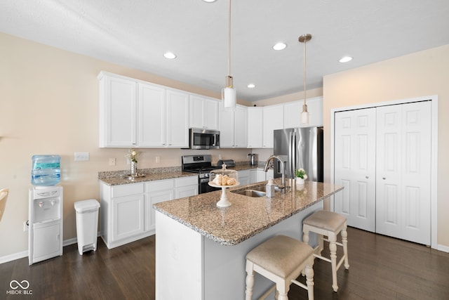 7067 Hart St, Cumberland, IN 46229 - kitchen with appliances with stainless steel finishes, a sink, dark wood-type flooring, a kitchen breakfast bar, and recessed lighting