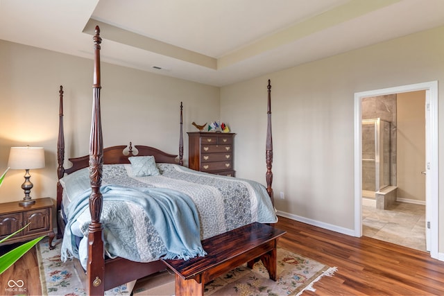 52 E 286th St, Atlanta, IN 46031 - bedroom featuring wood finished floors, connected bathroom, a tray ceiling, baseboards, and visible vents